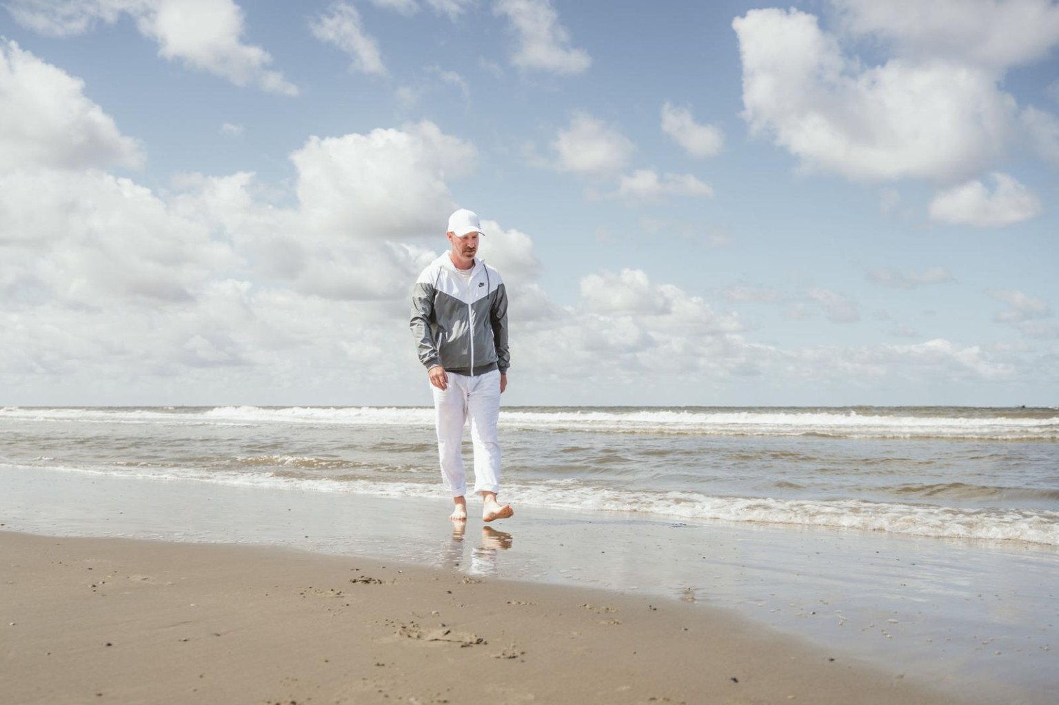Steffen Kairies geht barfuß am Strand entlang.
