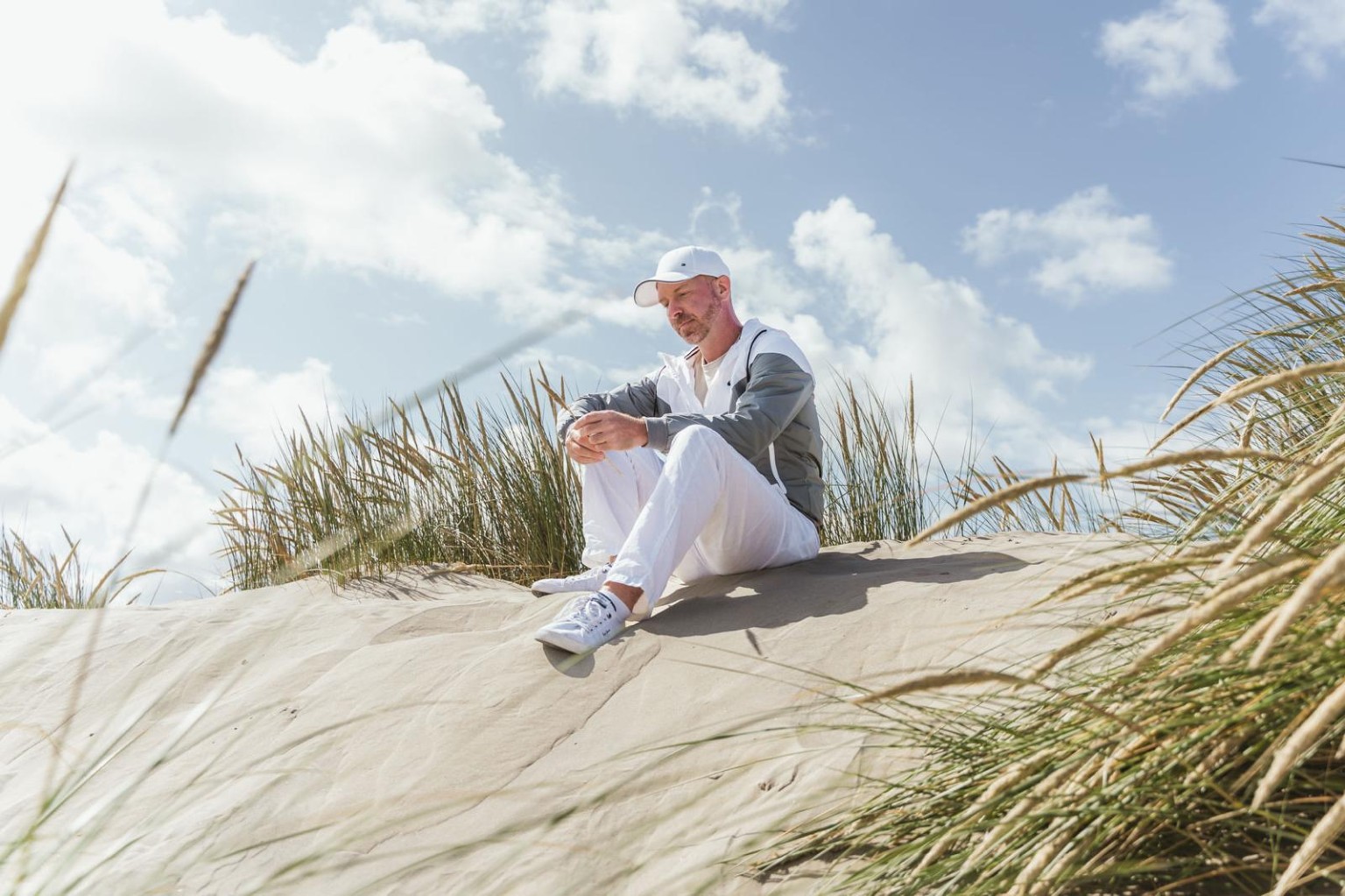 Steffen Kairies sitzend in den Dünen.